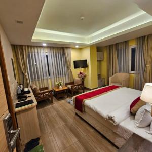 ein Hotelzimmer mit einem Bett und einem Wohnzimmer in der Unterkunft Hotel Krishna Kathmandu in Kathmandu