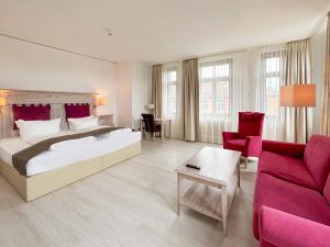 a bedroom with a large bed and a living room at DORMERO Schlosshotel Reichenschwand in Reichenschwand
