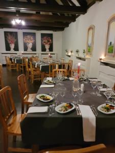 uma sala de jantar com uma mesa longa com pratos de comida em Šlokenbekas Muiža em Milzkalne