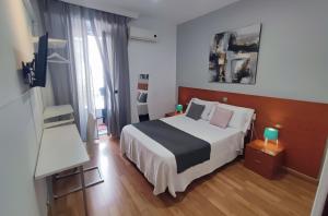Habitación de hotel con cama y ventana en Hostal Cervantes, en Madrid