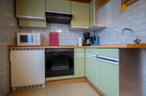 eine Küche mit einem Kühlschrank und einer Mikrowelle in der Unterkunft Ferienwohnung Beate in Alsfassen