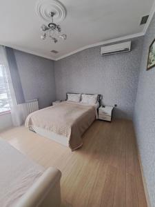 a bedroom with a bed and a chandelier at RA Hotel in Qusar