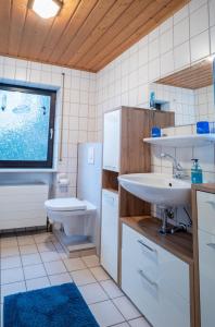 ein Badezimmer mit einem Waschbecken, einer Badewanne und einem WC in der Unterkunft Ferienwohnung Beate in Alsfassen