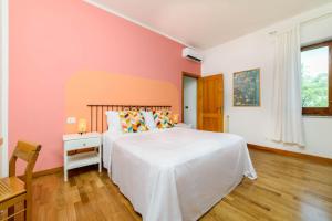 a bedroom with a white bed and a pink wall at B&B Albachiara Casa di Campagna in Ogliastro Cilento