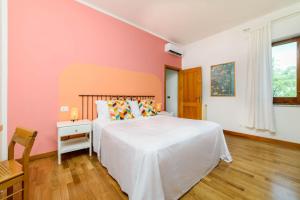 een slaapkamer met een wit bed en een roze muur bij B&B Albachiara Casa di Campagna in Ogliastro Cilento