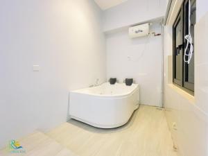 ein weißes Bad mit einem Waschbecken im Zimmer in der Unterkunft Sunway Grid Residence @ UHA in Kampong Pendas