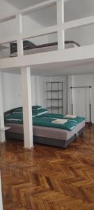a bedroom with a bunk bed and a wooden floor at Kriston Apartman 2 in Miskolc