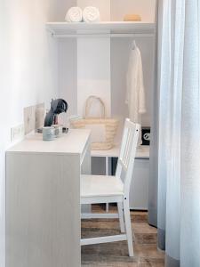 une chaise blanche assise sur un bureau dans la cuisine dans l'établissement Hostal Perla Blanca Altea, à Altea