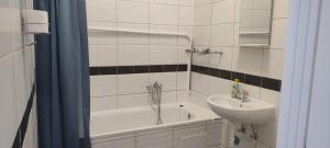 米什科爾茨的住宿－Kriston Apartman 2，浴室配有盥洗盆、浴缸和盥洗盆
