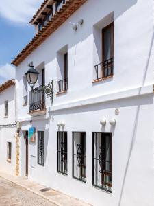 a white building with black windows and a street at Hostal Perla Blanca Altea in Altea