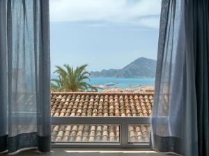 ventana con vistas a la playa y al océano en Hostal Perla Blanca Altea, en Altea