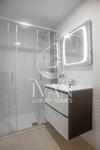 une salle de bains avec douche, lavabo et miroir dans l'établissement Casa Sol Ivan Luxury Homes 10ªPlta Sur 1ªLinea, à Oropesa del Mar