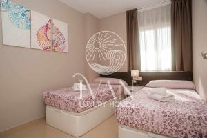 une petite chambre avec deux lits et une table dans l'établissement Casa Sol Ivan Luxury Homes 10ªPlta Sur 1ªLinea, à Oropesa del Mar
