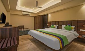 a bedroom with a large bed and a television at Treebo Trend Pink City Grand in Jaipur
