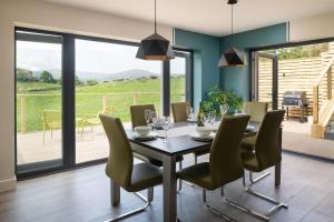 a dining room with a table and chairs at Ty Uchaf Cottage in Llansantffraid Glan Conwy