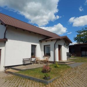 Casa blanca con mesa y banco en Agroturystyka Kaszuby, en Parchowo