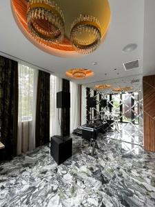 um quarto amplo com piso em mármore e um tecto dourado em Hotel Codrişor em Bistrita