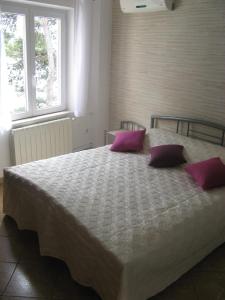 a bedroom with a large bed with purple pillows at Apartments & Room Nina in Korčula