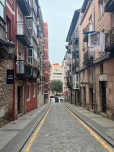 an empty street in an alley between buildings at Homely Rooms in Santander