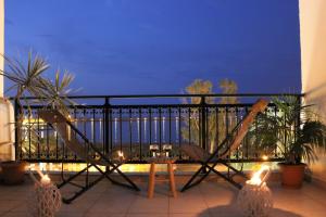 a balcony with a railing and a table and plants at Théa Apartment in Rethymno Town
