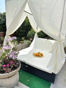 Una cama blanca con fruta en un jardín en Villa Nika 3, en Ika