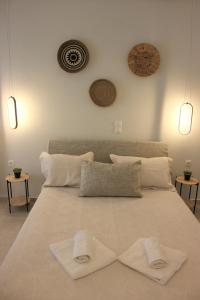 a large white bed with two white towels on it at Théa Apartment in Rethymno Town