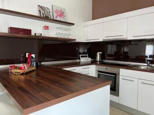 a kitchen with white cabinets and a wooden counter top at Apartment HUMAC, Ljubuški in Ljubuški