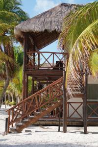 a hut with a straw roof on a beach at Grand Slam Fishing Lodge Tulum in Punta Allen