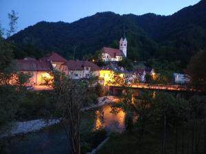 a town at night with a bridge and a church at Riverside Villa Avo - Apartment AVO in Spodnja Idrija