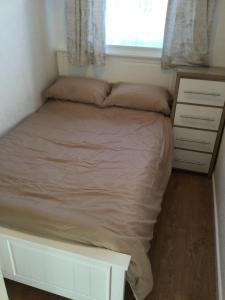 a bed in a small bedroom with a window at Hillview in Brean