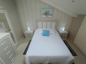 1 dormitorio con cama blanca y almohada azul en Fogar San Sadurniño en Cambados