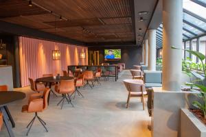 un ristorante con tavoli e sedie e un bar di Struer Grand Hotel a Struer
