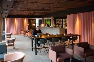 a man sitting at a table in a restaurant at Struer Grand Hotel in Struer