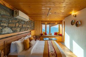 um quarto com uma cama com uma parede de pedra em StayVista at DAAFI House with Comp Breakfast em Theog