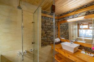 uma casa de banho com um lavatório e um chuveiro em StayVista at DAAFI House with Comp Breakfast em Theog