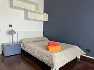 ein Schlafzimmer mit einem Bett mit zwei roten Bögen darauf in der Unterkunft CconfortHotels Appartamento SkyLine - SELF CHECK IN in Bari