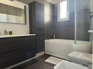 ein Badezimmer mit einer Badewanne, einem WC und einem Waschbecken in der Unterkunft CconfortHotels Appartamento SkyLine - SELF CHECK IN in Bari