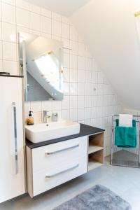 ein Bad mit einem Waschbecken und einem Spiegel in der Unterkunft Haus Rosy Ferienwohnung in Stubenberg