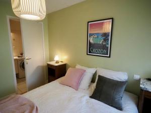 Un dormitorio con una cama blanca con dos almohadas. en KER HERA.Bain de lumière à ETEL, en Étel
