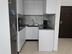 eine weiße Küche mit einer Spüle und einem Kühlschrank in der Unterkunft Bjora Home in Vlorë