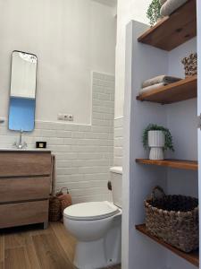 a bathroom with a white toilet and a mirror at Doña Josefina y Don Simón in Almería
