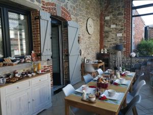 a dining room with tables and chairs and a brick wall at La Parenthèse Avesnoise in Limont-Fontaine