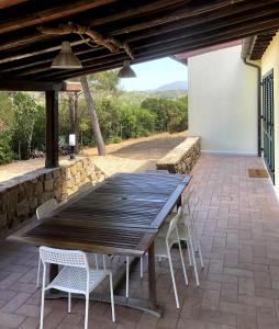 a wooden table and chairs on a patio at Elba Villa Colle - Nel verde ma vicina al mare in Marina di Campo