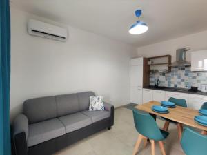 - un salon avec un canapé et une table dans l'établissement Appartamento Girasole by Holiday World, à Pachino