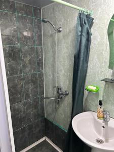 een badkamer met een douche en een wastafel bij Homestay Seaside by Manuchar in Batoemi