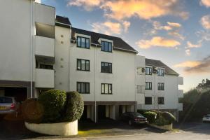 un edificio blanco con coches estacionados en un estacionamiento en Quarry Heights, en Bowness-on-Windermere