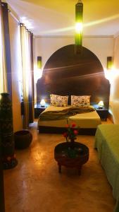 una habitación de hotel con 2 camas y una mesa con flores en Riad Karmanda, en Marrakech