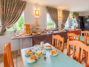 uma sala de jantar com uma mesa com comida em B&B HOTEL Strasbourg Aéroport em Holtzheim