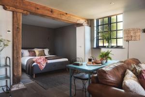 a living room with a bed and a couch and a table at Exe Valley Retreat in Exeter