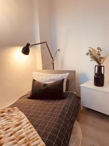 a bedroom with a bed with a lamp and a pillow at Ferienwohnung Altstadtblick in Emden